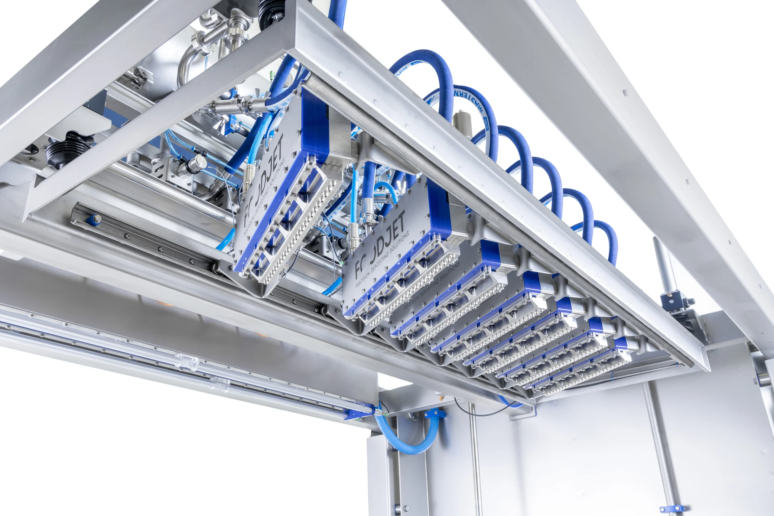 Row of depositing heads with blue air lines in the frame of a FoodJet depositor