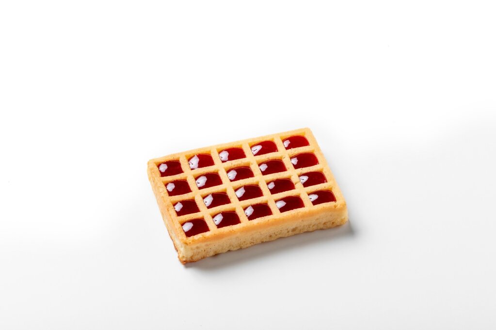 Waffle with red jam deposited in every square cavity