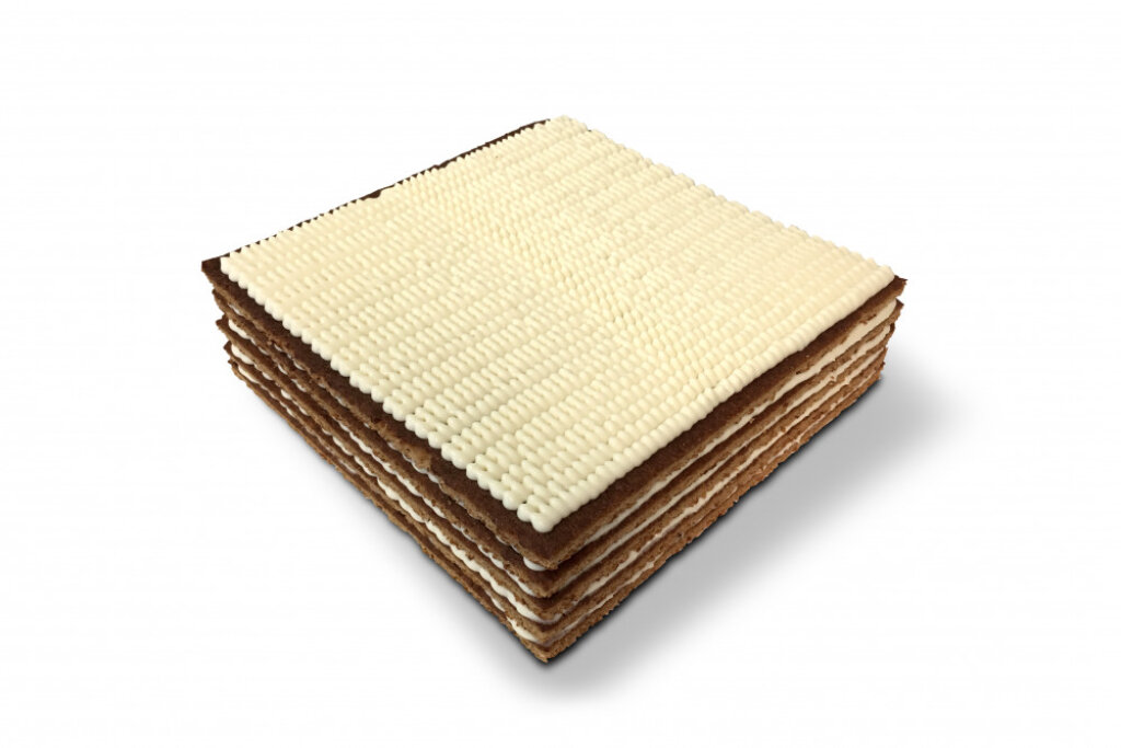 Layered cake of thin rectangular cake bases with a cream layer between each base and rows of cream drops on top