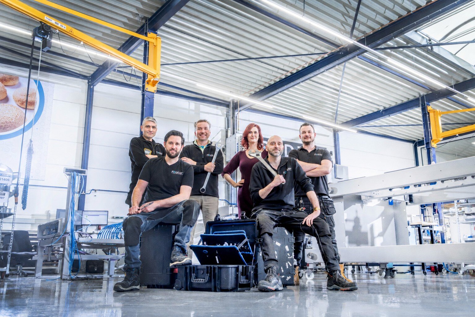 Six FoodJet team members with tools in the assembly hall